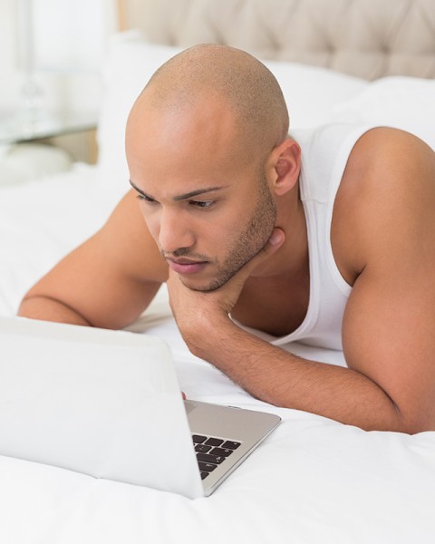 man kijkt op laptop